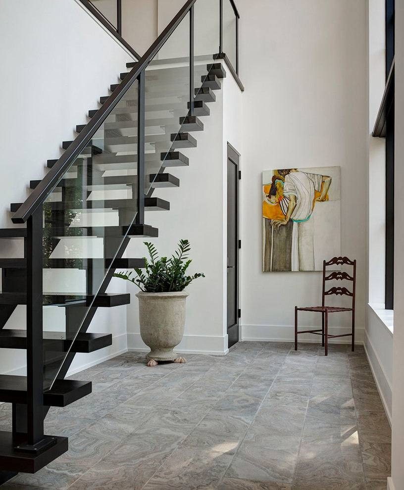 This is an example of a contemporary foyer in Detroit with white walls and grey floor.