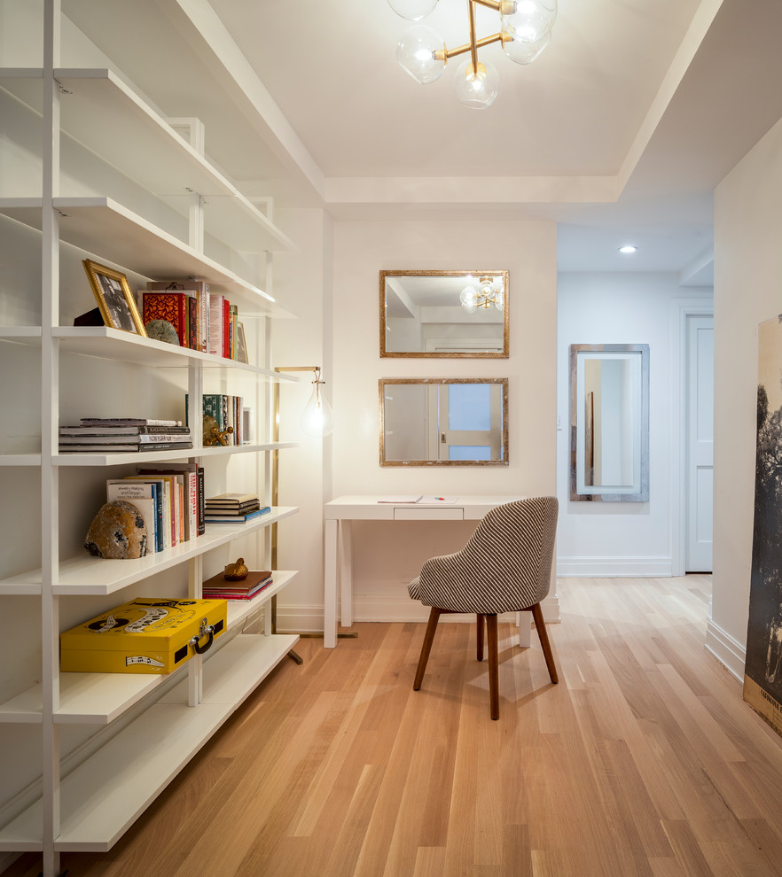 Photo of a contemporary hallway in New York with white walls, medium hardwood floors and brown floor.