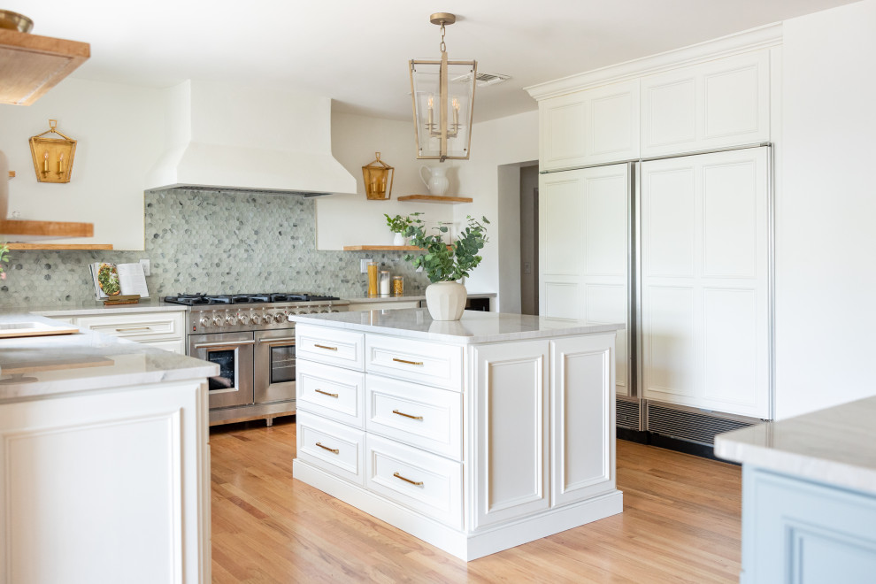 Exempel på ett mellanstort maritimt vit vitt kök, med en undermonterad diskho, luckor med infälld panel, vita skåp, bänkskiva i kvartsit, blått stänkskydd, stänkskydd i glaskakel, rostfria vitvaror, ljust trägolv, flera köksöar och brunt golv