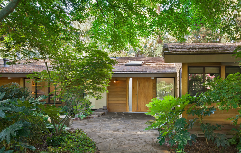 Photo of a midcentury exterior in Sacramento with wood siding.
