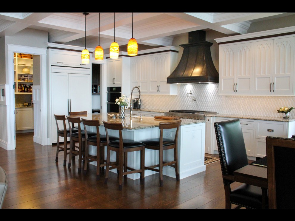 Example of a large transitional l-shaped medium tone wood floor, brown floor and coffered ceiling open concept kitchen design with a farmhouse sink, recessed-panel cabinets, white cabinets, granite countertops, white backsplash, stainless steel appliances, an island and beige countertops