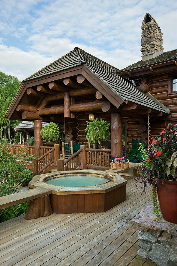 Expansive country side yard round natural pool in Chicago with a hot tub and decking.