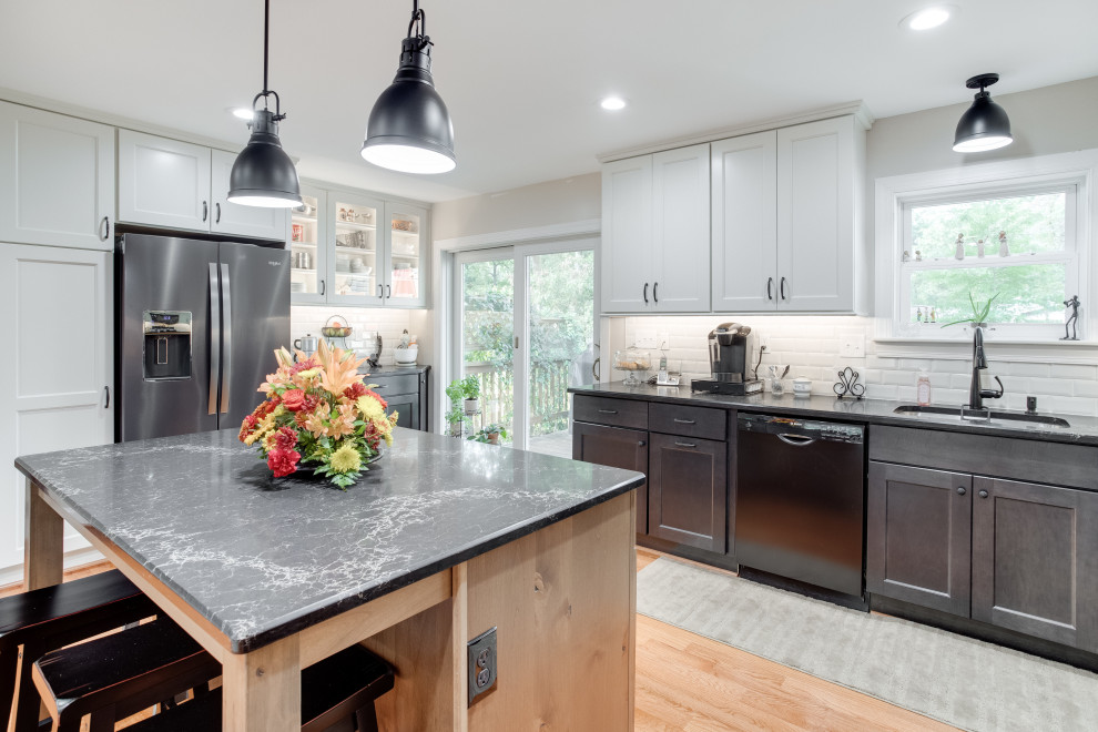 Large transitional u-shaped kitchen photo in Baltimore with recessed-panel cabinets, quartz countertops, black appliances and an island