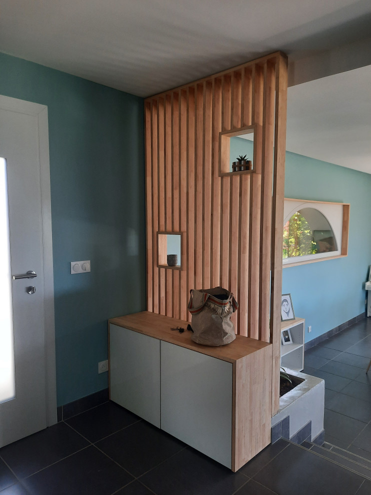 Cette photo montre une porte d'entrée tendance de taille moyenne avec un mur bleu, un sol en carrelage de céramique, une porte simple, une porte blanche et un sol gris.