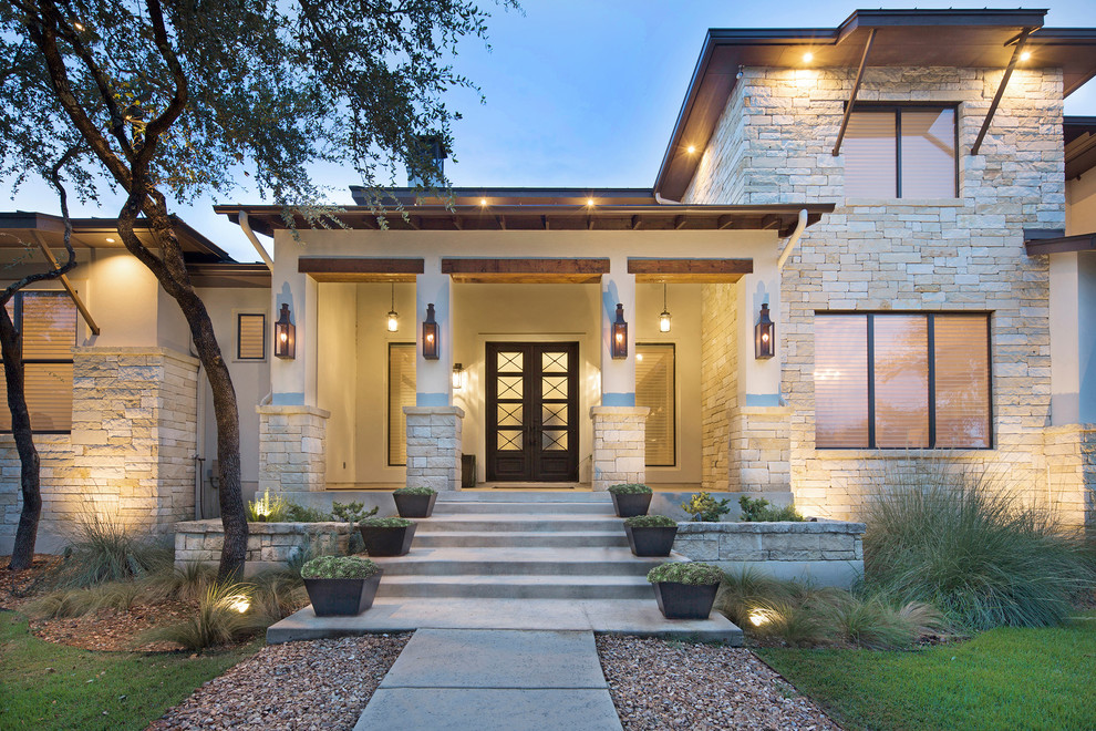Large transitional two-storey white house exterior in Other with stone veneer and a metal roof.
