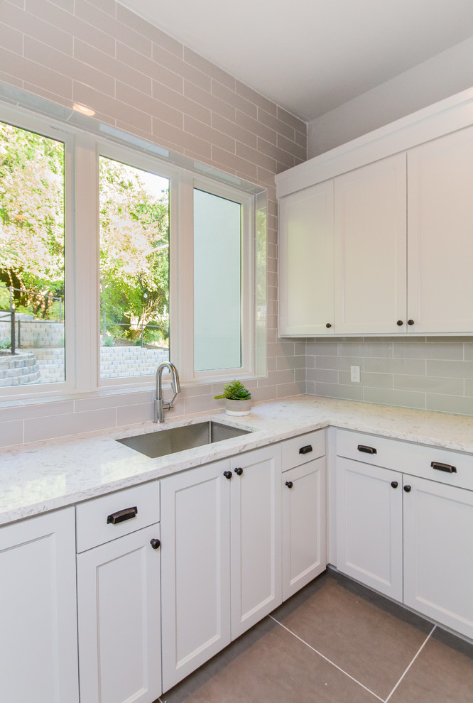 Design ideas for a large country l-shaped utility room in Austin with an undermount sink, shaker cabinets, grey cabinets, quartz benchtops, grey walls, porcelain floors and a side-by-side washer and dryer.