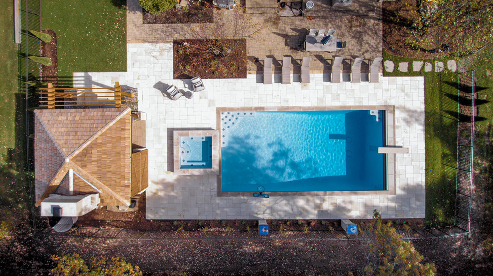 Large mountain style backyard concrete paver and rectangular lap pool photo in Chicago