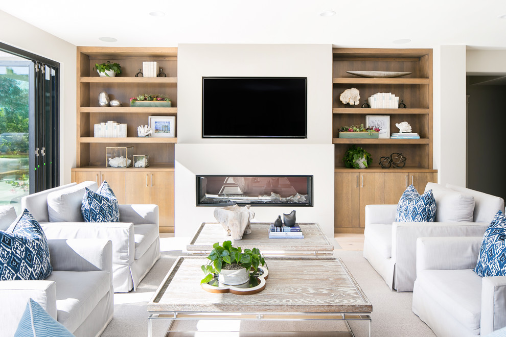 Beach style open concept family room in San Diego with a ribbon fireplace, a wall-mounted tv and white walls.