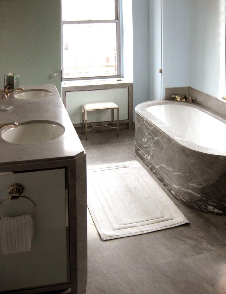 Photo of a mid-sized transitional master bathroom in New York with an undermount sink, glass-front cabinets, grey cabinets, granite benchtops, an undermount tub, an alcove shower, gray tile, stone slab, blue walls and marble floors.