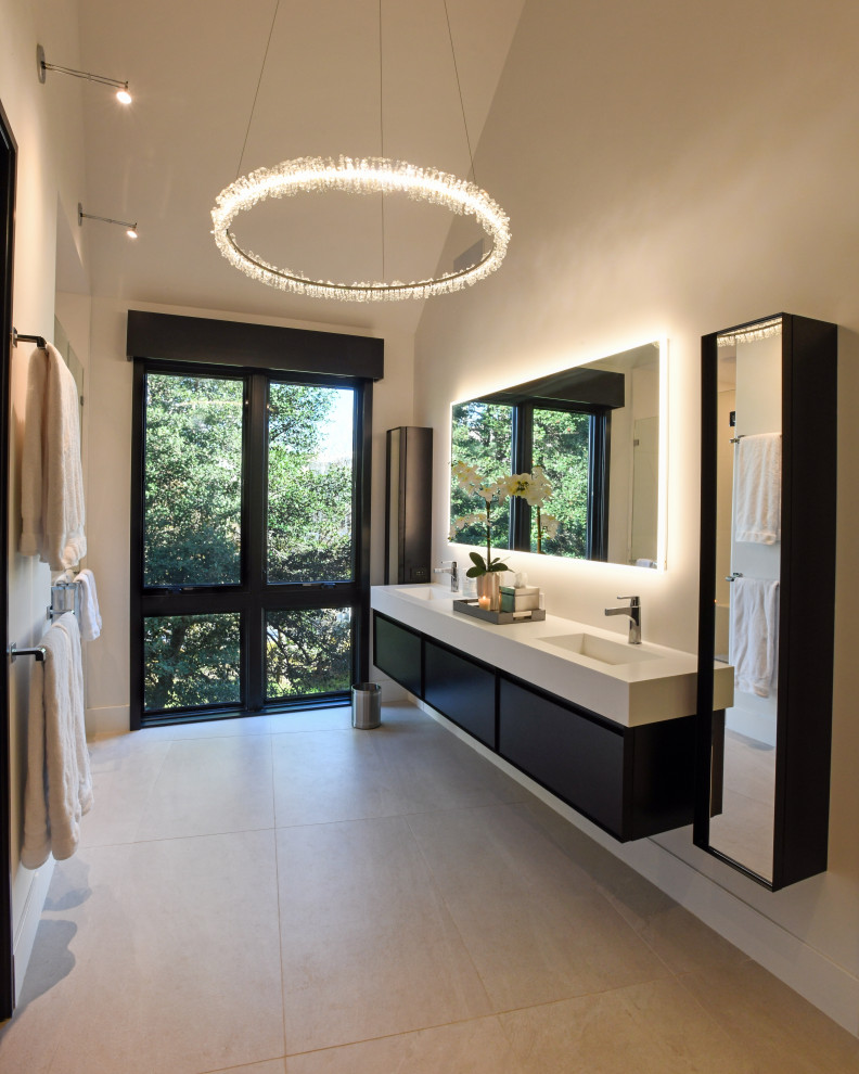Cette photo montre une grande salle de bain principale tendance avec placards, des portes de placard marrons, meuble double vasque, meuble-lavabo suspendu et un plafond voûté.