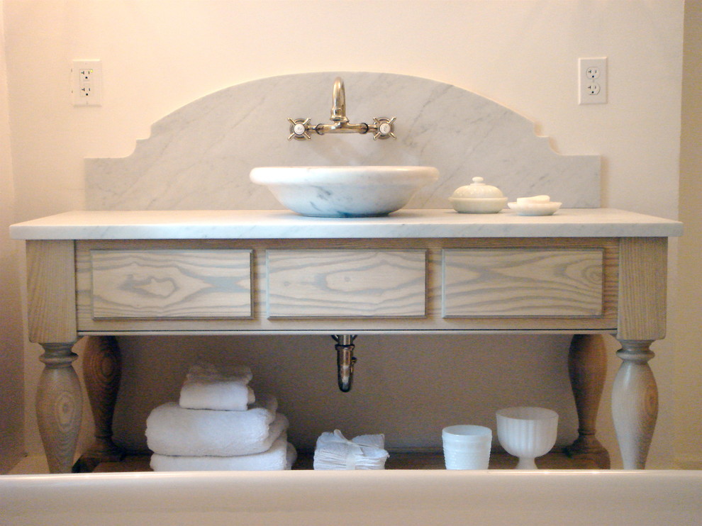 This is an example of a small country 3/4 bathroom in New York with a vessel sink, marble benchtops, white walls, light hardwood floors, furniture-like cabinets, white cabinets and a two-piece toilet.