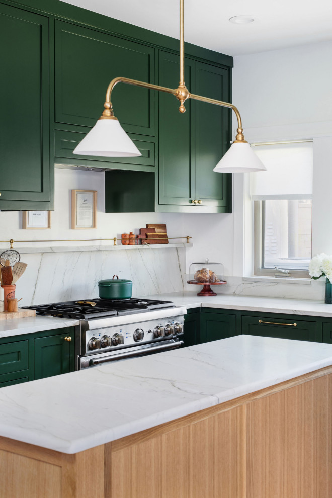 Open concept kitchen - mid-sized transitional u-shaped medium tone wood floor and brown floor open concept kitchen idea in Austin with an undermount sink, shaker cabinets, green cabinets, quartzite countertops, white backsplash, stone slab backsplash, stainless steel appliances, an island and white countertops