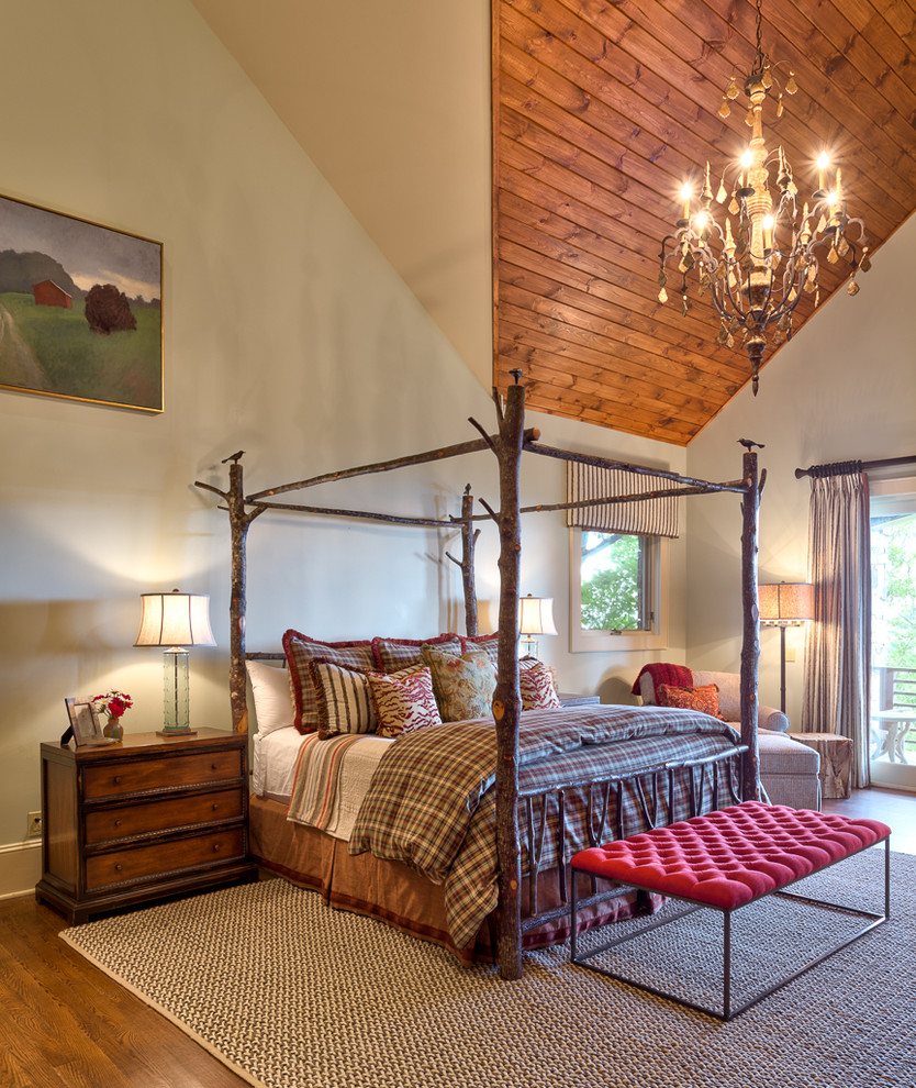 Design ideas for a large country master bedroom in Charlotte with beige walls and medium hardwood floors.