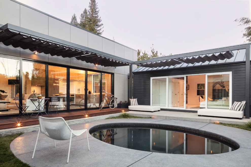 Contemporary round pool in San Francisco with concrete slab.