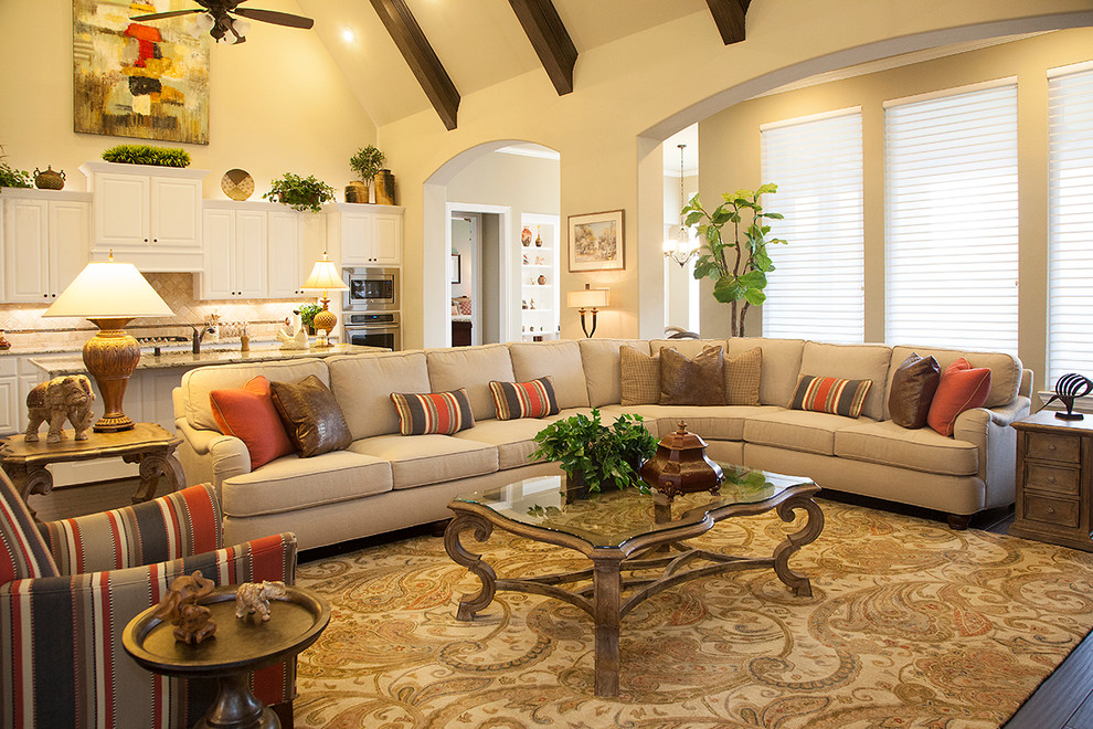 Design ideas for a traditional open concept family room in Houston with beige walls and dark hardwood floors.