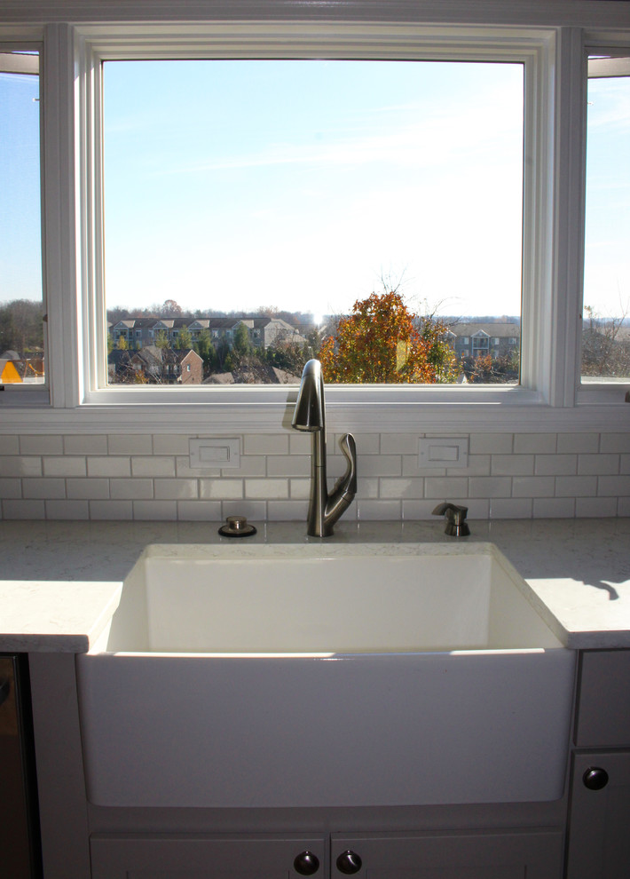 Eat-in kitchen - mid-sized transitional galley medium tone wood floor eat-in kitchen idea in Cincinnati with a drop-in sink, gray cabinets, white backsplash, subway tile backsplash, stainless steel appliances and an island