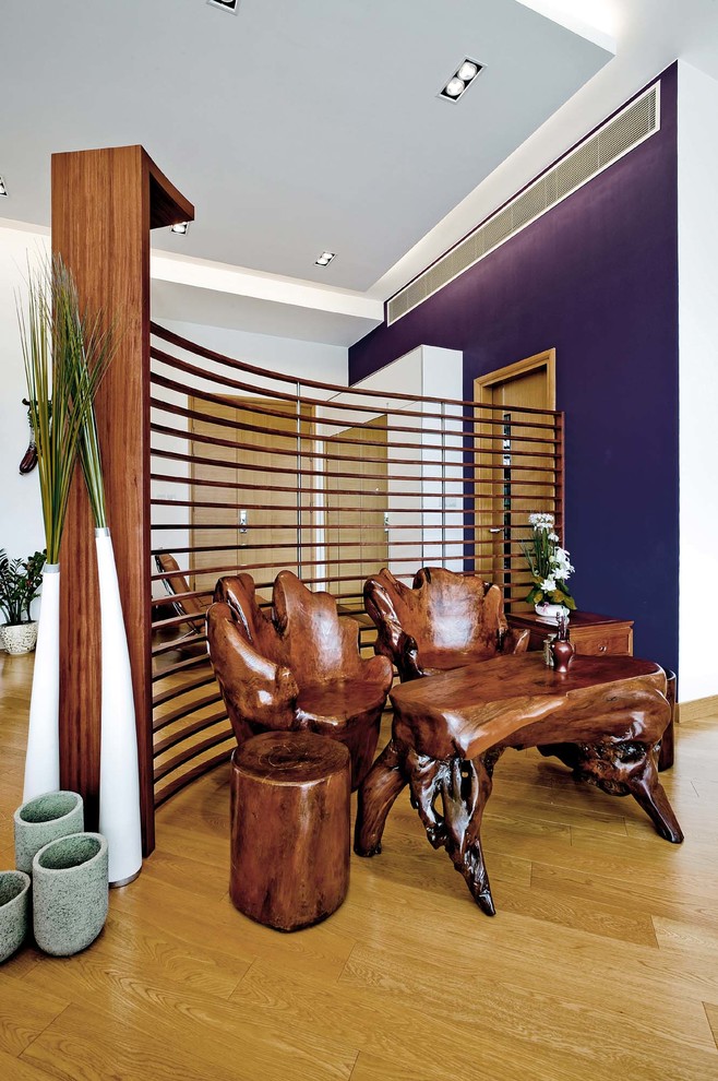 This is an example of a contemporary entryway in Hong Kong with purple walls and light hardwood floors.