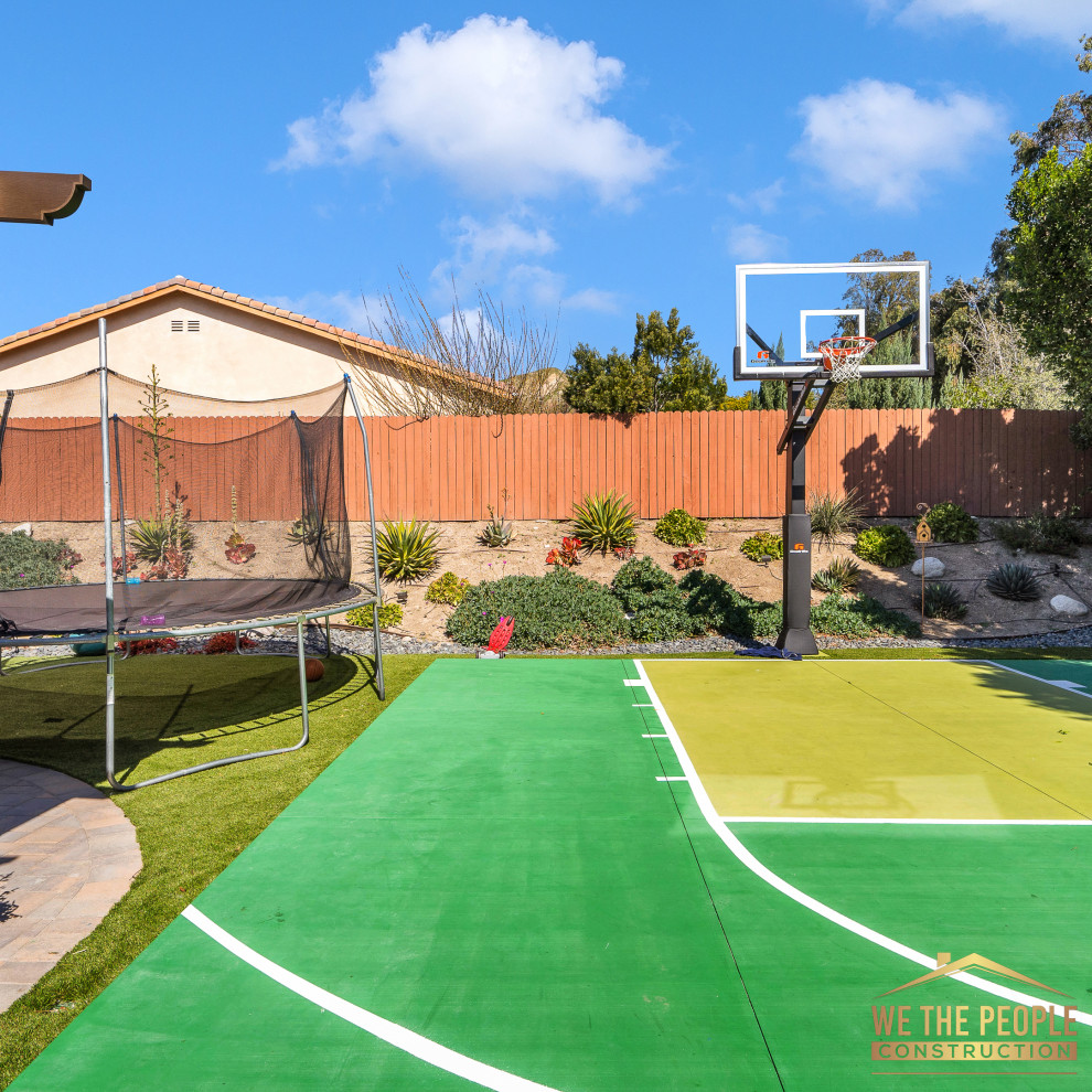 Photo of a large back partial sun garden for spring in Los Angeles with an outdoor sport court, a desert look, gravel and a wood fence.