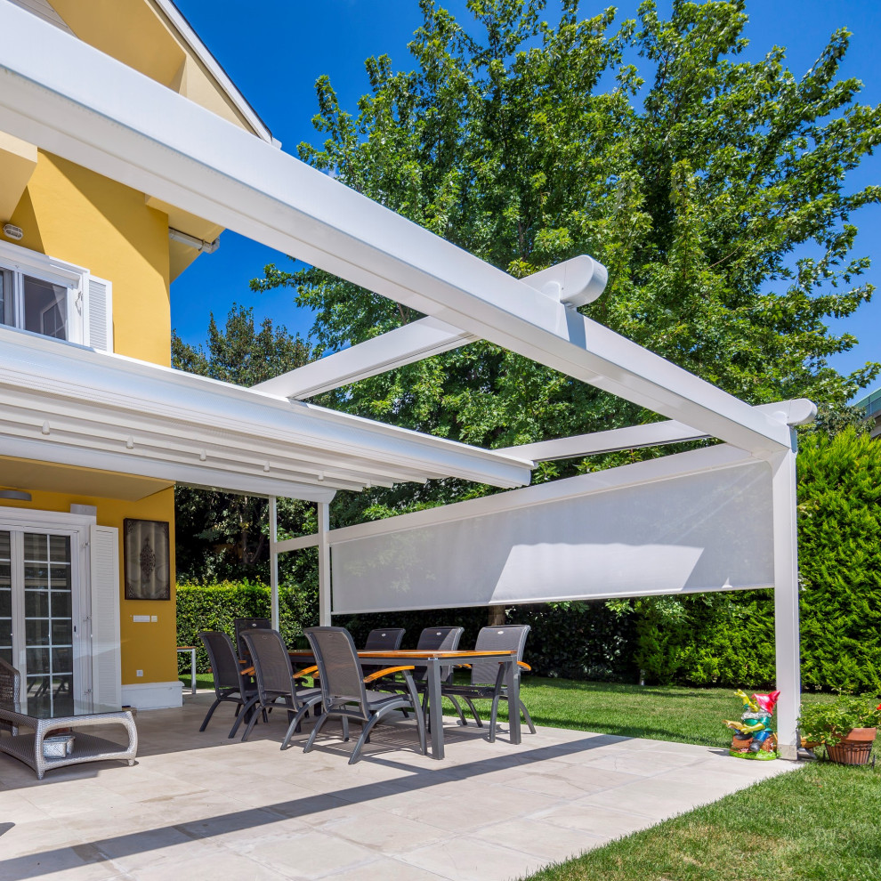 Mid-sized farmhouse side yard ground level privacy deck photo in Munich with a pergola
