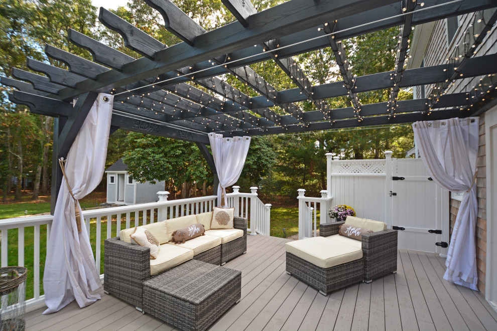 Large backyard and ground level deck in Boston with with privacy feature and a pergola.