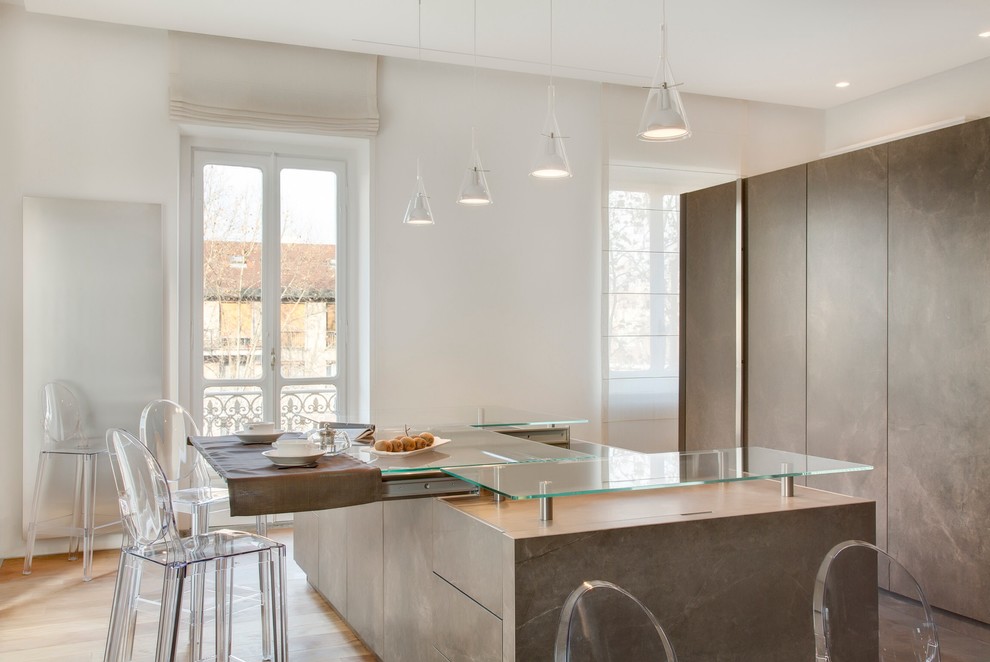 Contemporary single-wall eat-in kitchen in Turin with a single-bowl sink, flat-panel cabinets, brown cabinets, brown splashback, glass sheet splashback, stainless steel appliances, light hardwood floors, with island and glass benchtops.
