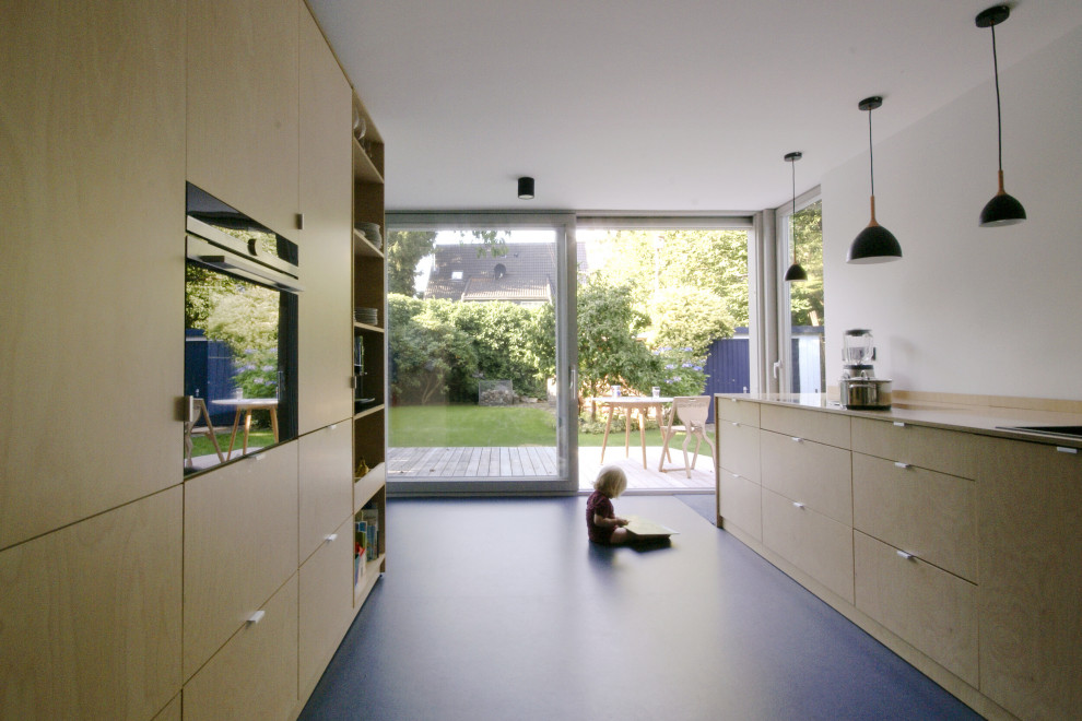 На фото: прямая кухня-гостиная в современном стиле с накладной мойкой, плоскими фасадами, светлыми деревянными фасадами, деревянной столешницей, полом из линолеума и синим полом с