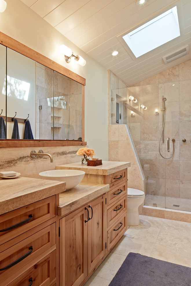 Design ideas for a country bathroom in San Francisco with a vessel sink, shaker cabinets, medium wood cabinets, an alcove shower, beige tile, beige walls and travertine.