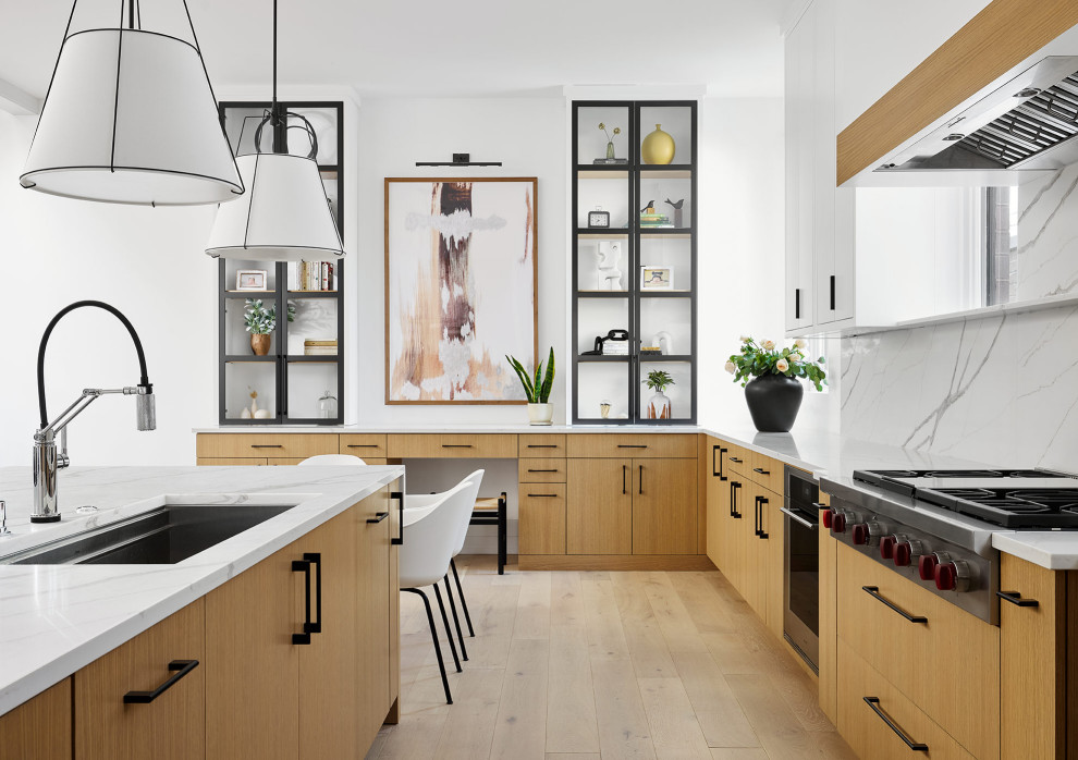 Photo of a modern open plan kitchen in Chicago with flat-panel cabinets, light wood cabinets, quartz benchtops, white splashback, engineered quartz splashback, light hardwood floors, with island and white benchtop.