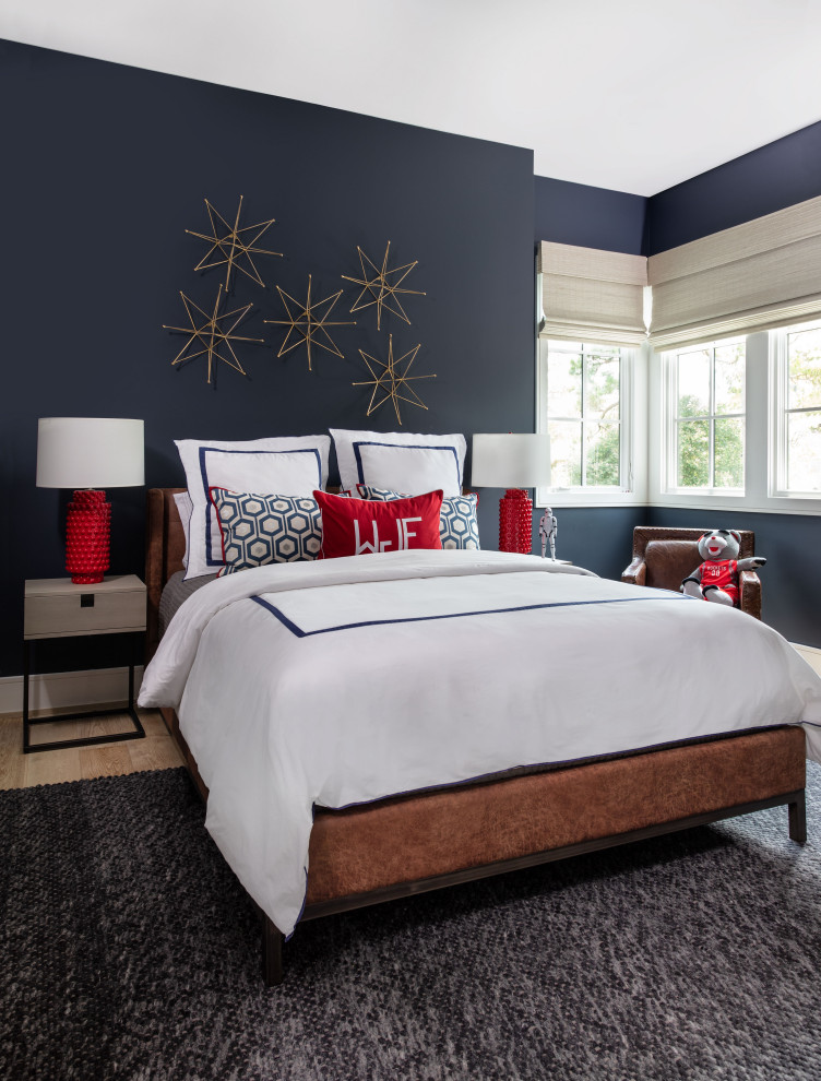 This is an example of a large transitional kids' bedroom for kids 4-10 years old and boys in Houston with blue walls, light hardwood floors and brown floor.
