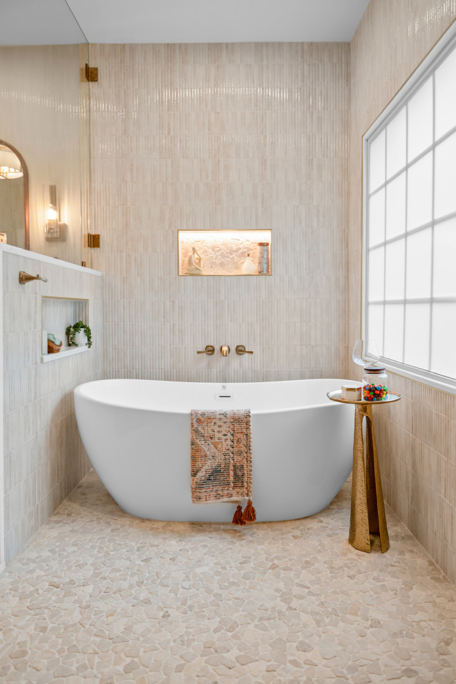 Inspiration for a transitional pebble tile floor and beige floor freestanding bathtub remodel with beige walls and a niche
