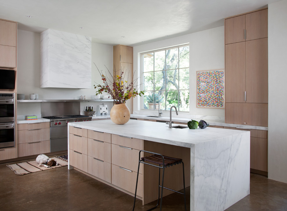Mediterranean l-shaped kitchen in Austin with flat-panel cabinets, medium wood cabinets and with island.