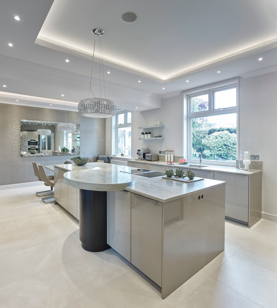 Large contemporary l-shaped eat-in kitchen in Other with flat-panel cabinets, solid surface benchtops, porcelain floors, with island, a drop-in sink, beige cabinets, stainless steel appliances, beige floor and beige benchtop.