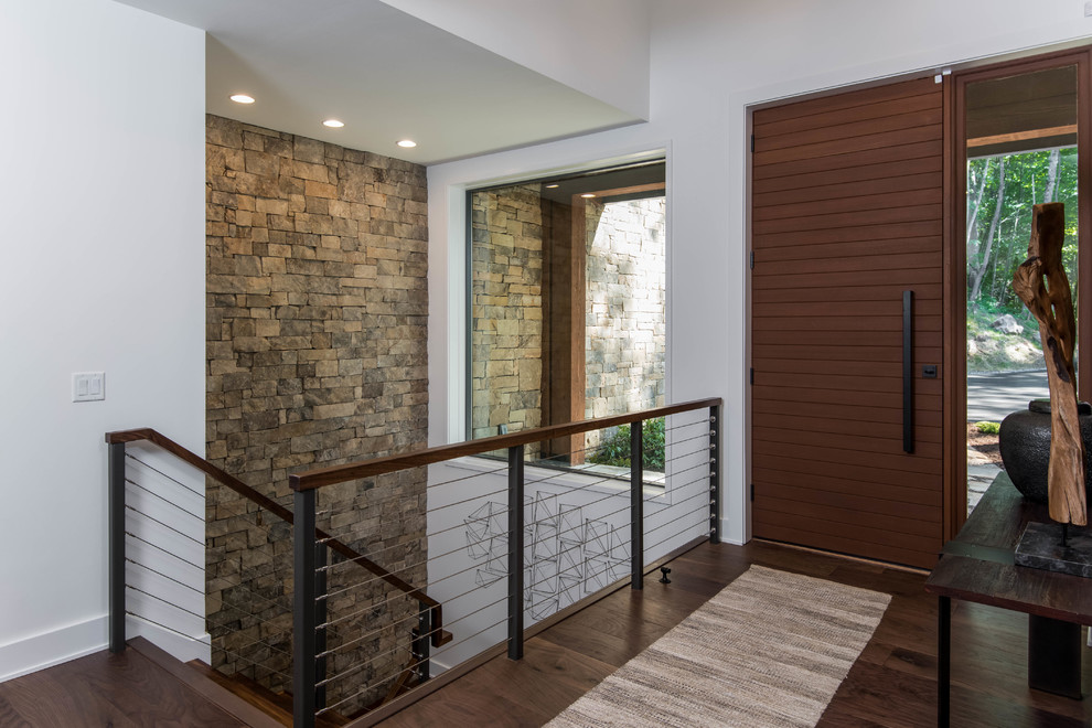 Organic Modern Mountain Home - A warm and inviting rustic modern entry features a harmonious mix of wood, stone, and organic materials, embodying sustainable and energy-efficient design in this luxurious mountain home.