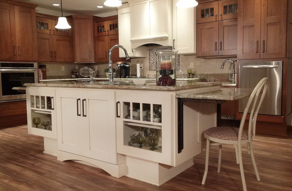 Example of a large transitional l-shaped medium tone wood floor open concept kitchen design with an undermount sink, shaker cabinets, medium tone wood cabinets, granite countertops, beige backsplash, ceramic backsplash, white appliances and an island