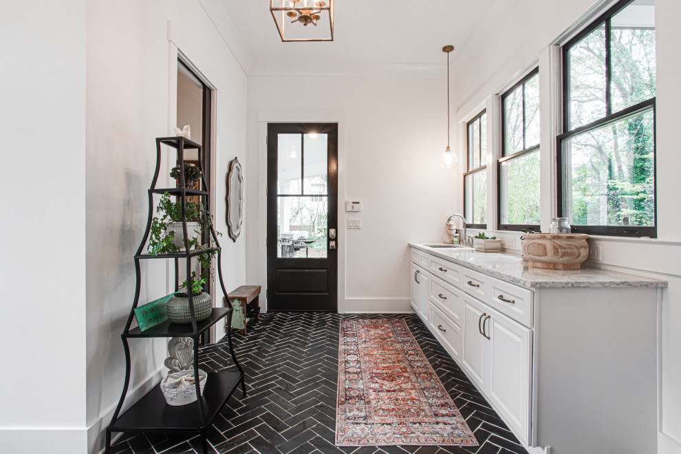 Design ideas for a mid-sized country galley dedicated laundry room in Atlanta with an undermount sink, shaker cabinets, white cabinets, granite benchtops, granite splashback, white walls, limestone floors, a side-by-side washer and dryer, black floor and multi-coloured benchtop.