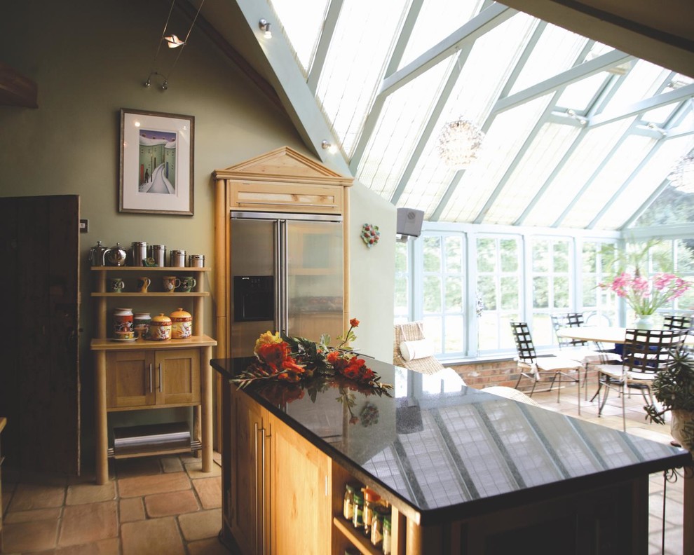 Mid-sized traditional eat-in kitchen in Kent with shaker cabinets, medium wood cabinets, granite benchtops, black splashback, stainless steel appliances, travertine floors and with island.