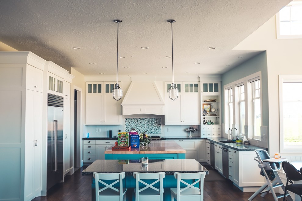 Inspiration for a large transitional u-shaped dark wood floor and brown floor eat-in kitchen remodel in Seattle with an undermount sink, recessed-panel cabinets, white cabinets, soapstone countertops, blue backsplash, mosaic tile backsplash, stainless steel appliances, two islands and black countertops