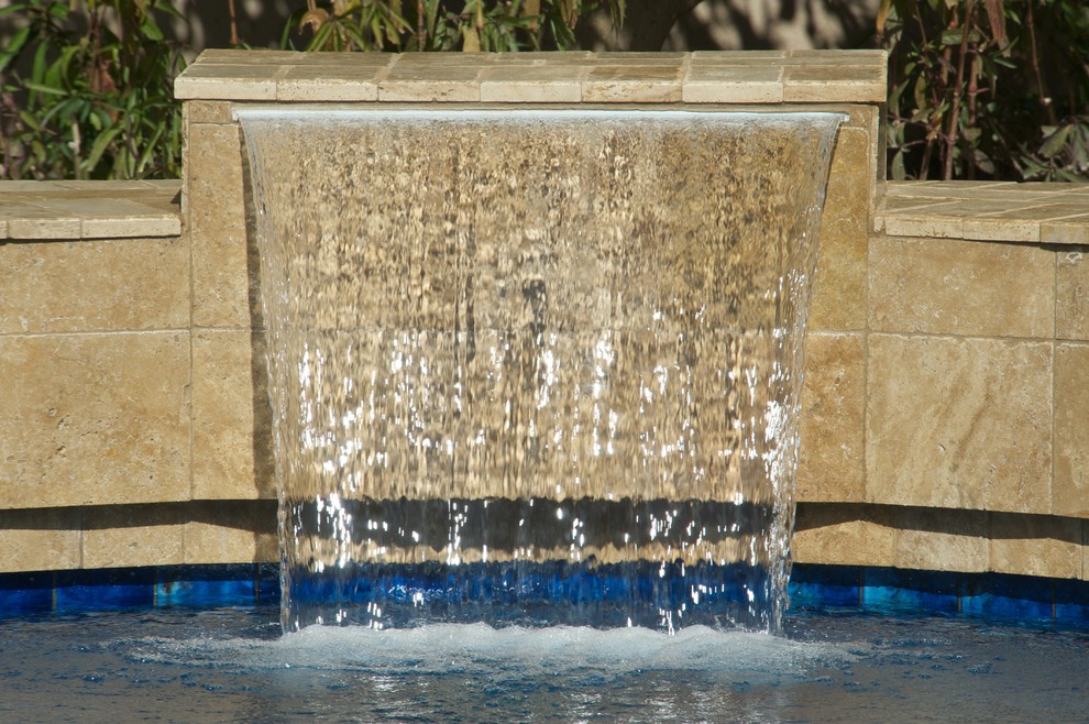 Design ideas for a mid-sized mediterranean backyard rectangular lap pool in Phoenix with a water feature and tile.