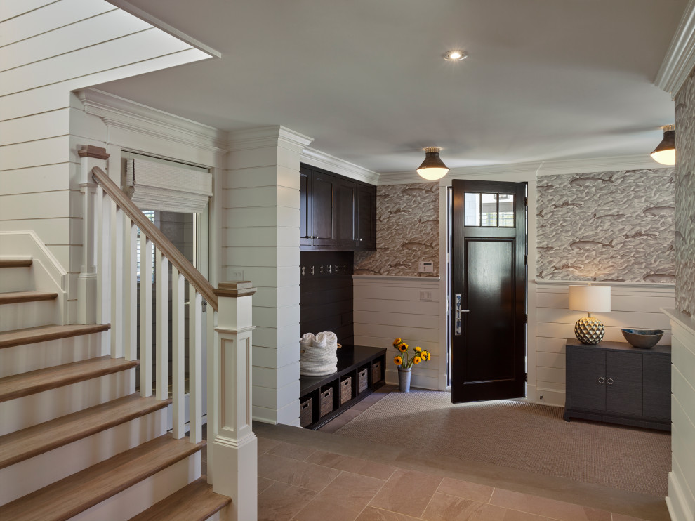 Photo of an expansive beach style foyer in Other with white walls, marble floors, a single front door, a black front door, beige floor and wallpaper.