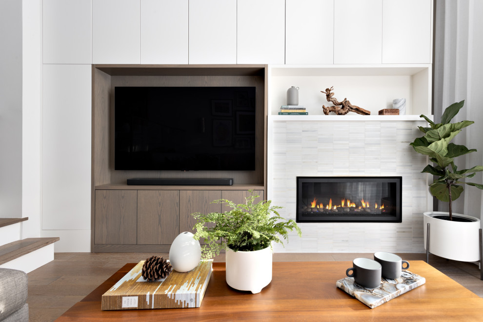 Design ideas for a mid-sized contemporary open concept living room in Vancouver with white walls, medium hardwood floors, a standard fireplace, a tile fireplace surround, a built-in media wall and brown floor.