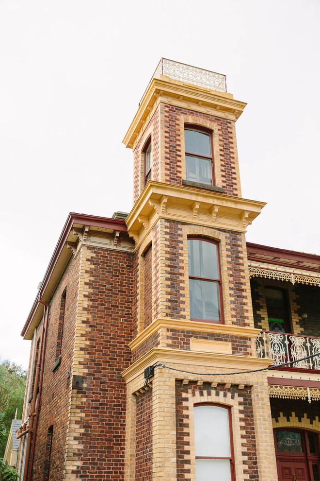 Design ideas for a large traditional two-storey brick brown exterior in Melbourne with a gable roof.