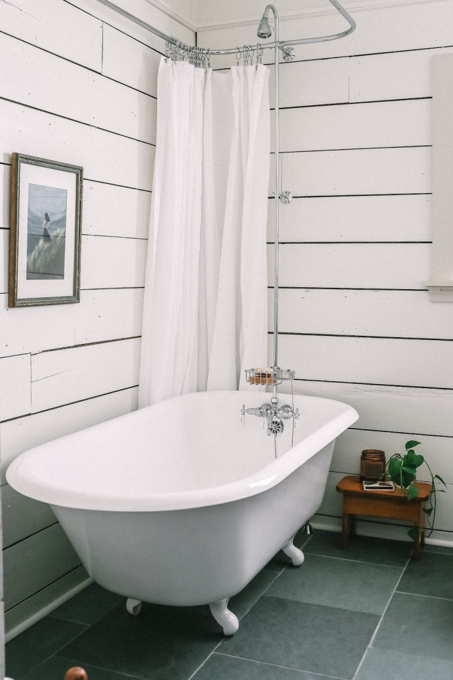 Photo of a small traditional bathroom in Dallas with dark wood cabinets, a claw-foot tub, a shower/bathtub combo, a one-piece toilet, white walls, limestone floors, a vessel sink, wood benchtops, grey floor, a shower curtain and brown benchtops.