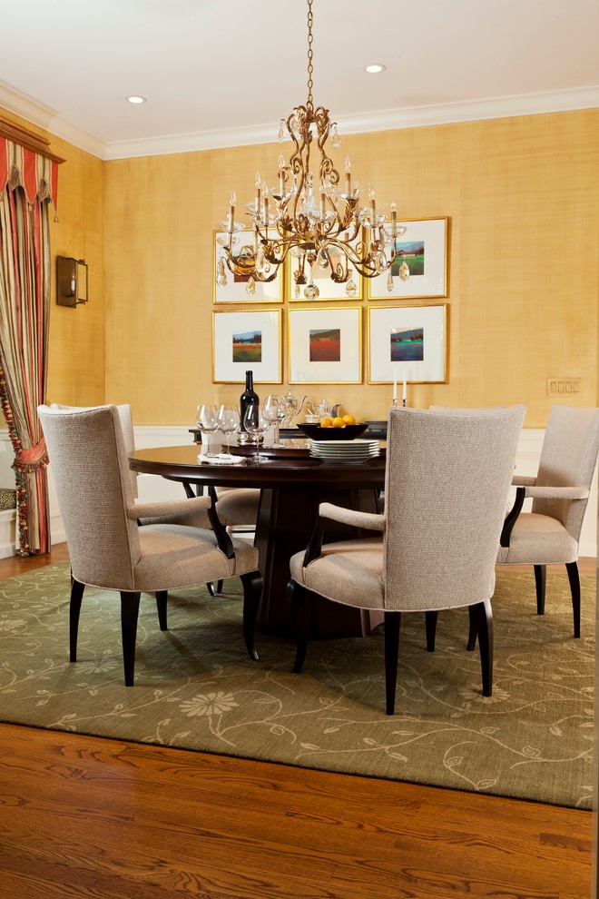 This is an example of a traditional dining room in San Francisco with yellow walls and dark hardwood floors.