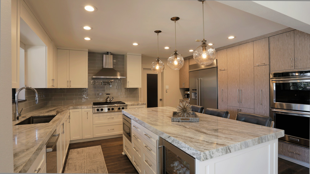 Design ideas for a mid-sized transitional u-shaped eat-in kitchen in Houston with with island, a single-bowl sink, shaker cabinets, white cabinets, granite benchtops, grey splashback, subway tile splashback, stainless steel appliances and medium hardwood floors.