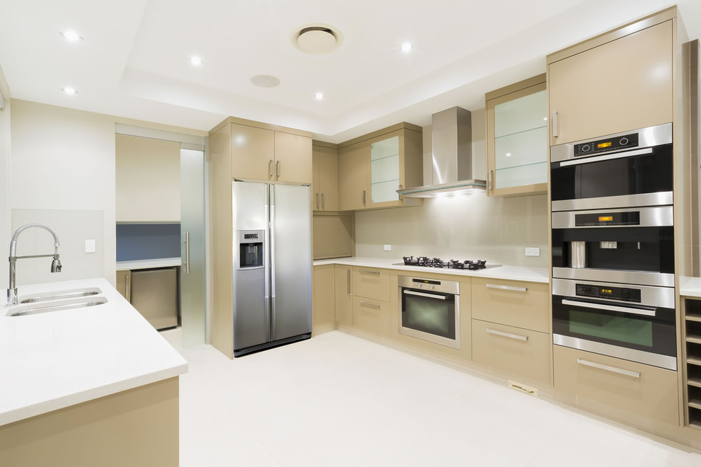 Design ideas for a small contemporary u-shaped kitchen pantry in Sydney with a double-bowl sink, beige cabinets, quartz benchtops, beige splashback, glass sheet splashback, stainless steel appliances, porcelain floors and grey floor.