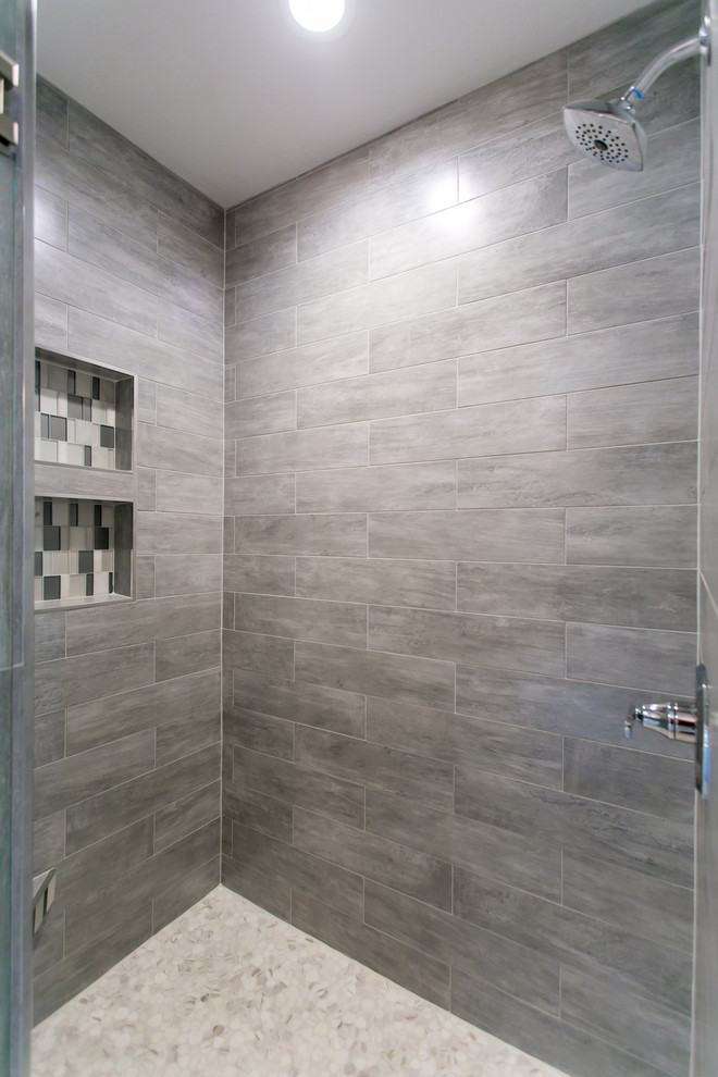 Design ideas for a mid-sized modern master bathroom in Seattle with shaker cabinets, dark wood cabinets, a corner tub, a two-piece toilet, gray tile, glass tile, grey walls, porcelain floors, an undermount sink, engineered quartz benchtops, grey floor and a hinged shower door.