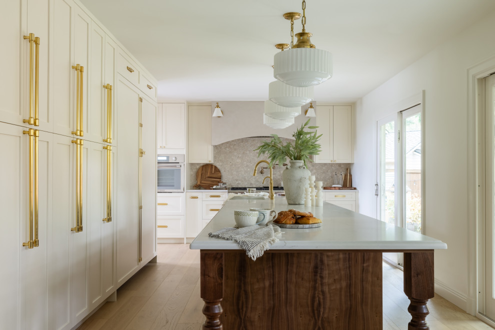 Inspiration for a transitional l-shaped light wood floor and beige floor kitchen remodel in Seattle with shaker cabinets, white cabinets, gray backsplash, an island and white countertops