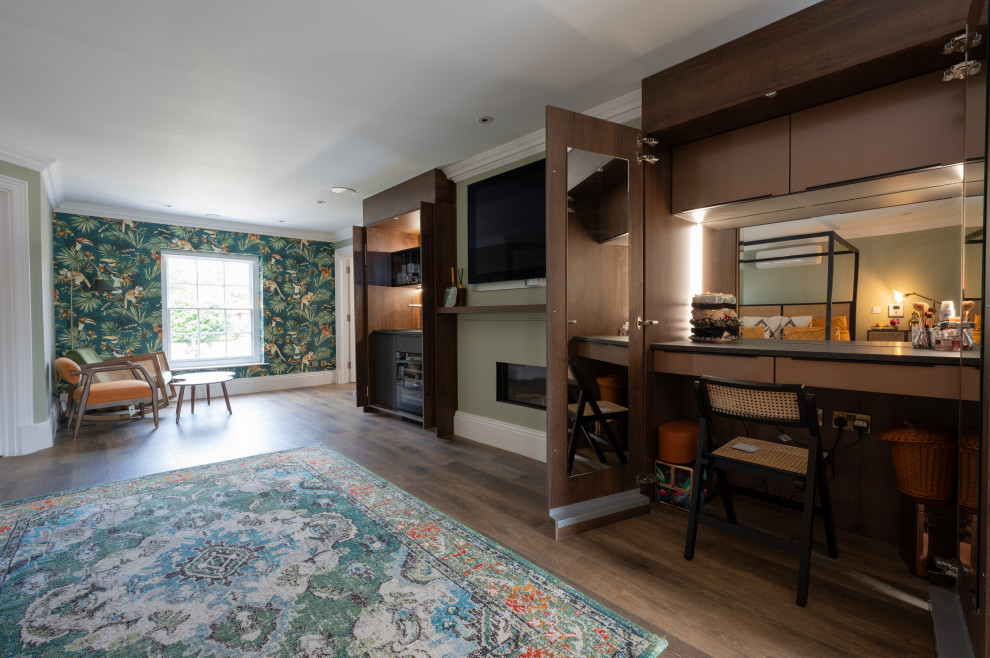 Cette photo montre une grande chambre parentale avec un mur vert, un sol en vinyl, une cheminée standard, un manteau de cheminée en brique, un sol marron et du papier peint.