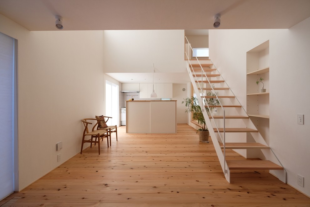 Inspiration for a small scandinavian wood straight staircase in Other with open risers and metal railing.