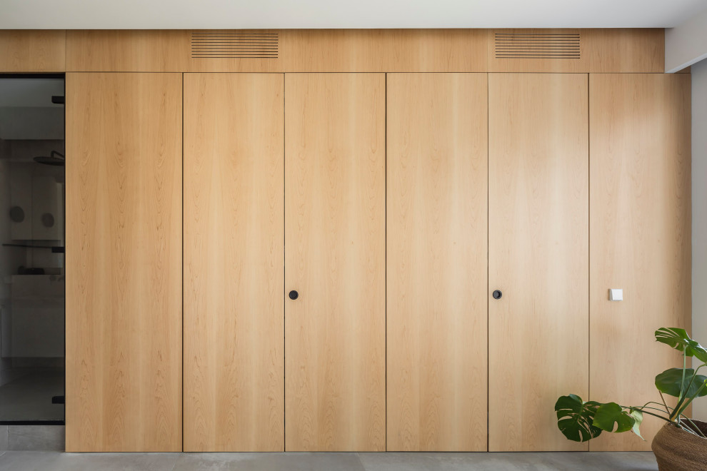 Ejemplo de armario vestidor unisex contemporáneo de tamaño medio con armarios con paneles empotrados, puertas de armario de madera oscura, suelo de baldosas de cerámica y suelo gris